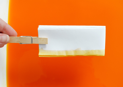 Step 03 // Dip one edge of the paper rectangle into warm dye bath